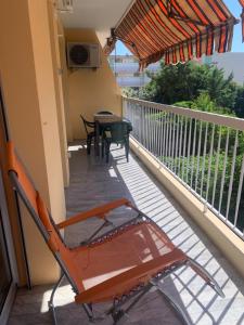 a deck with a table and chairs on a balcony at Agréable 2 pièces à 150 m de la mer in Cagnes-sur-Mer