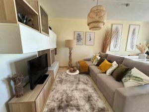 a living room with a couch and a flat screen tv at Mar de Fulles in Buarcos