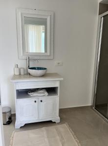 a white bathroom with a sink and a mirror at NOTO country farm house in Noto