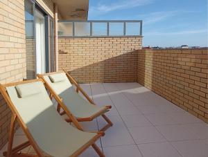 - deux chaises sur le balcon d'un bâtiment dans l'établissement Sunset Lounge CorgoMar, à Lavra
