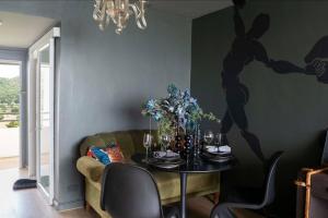 Getaway to Artist's Room Seaview في Ban Bo Kaeo: غرفة طعام مع طاولة و لوحة على الحائط
