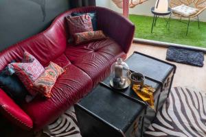 Getaway to Artist's Room Seaview في Ban Bo Kaeo: وجود أريكة حمراء في غرفة المعيشة مع طاولة