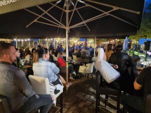 a group of people sitting in chairs under an umbrella at Kopićland TENT in Marinci