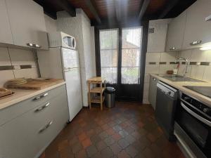 Una cocina con gabinetes blancos y un fregadero y una ventana. en Cotterg - Chalet individuel 15 pers, centre village et proches pistes de ski, en La Clusaz 8 fotos más