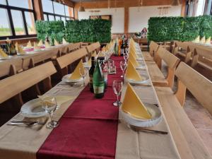 a long table with wine glasses and wine bottles at Kopićland TENT in Marinci