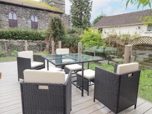 a patio with a glass table and chairs on a deck at Rydal Rock in Ambleside