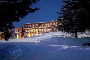 un grand bâtiment dans la neige la nuit dans l'établissement Les Arcs 1800 : Appartement ski in/out avec spa, à Bourg-Saint-Maurice
