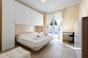 ein weißes Schlafzimmer mit einem Bett und einem Fenster in der Unterkunft Gran Fausto Trilo in San Felice del Benaco