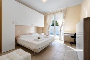 Un dormitorio blanco con una cama y una ventana. en Gran Fausto Trilo, en San Felice del Benaco