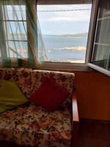 a couch in front of a window with a view of the ocean at Apartamento Carmen en Muxía in Muxia