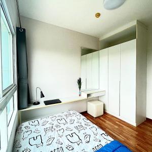 a bedroom with a bed and a desk and a window at The Trust condo 2 bed room Hua hin in Hua Hin