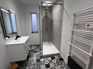 een witte badkamer met een douche en een wastafel bij Bengale - T2 complétement rénové tout confort in Vichy