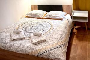 een bed met twee handdoeken erop bij Bengale - T2 complétement rénové tout confort in Vichy