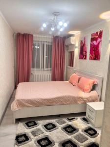a bedroom with a bed with pink sheets and pink pillows at 2-х комнатная квартира в центре in Almaty
