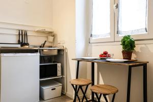 a small kitchen with a counter and stools in it at Giotto Studio Flat in Florence