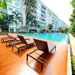a row of chairs sitting next to a swimming pool at The Trust condo 2 bed room Hua hin in Hua Hin