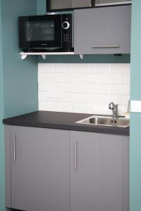 a kitchen with a sink and a microwave at Studio tout équipé centre-Ville proche de la gare in Cluses