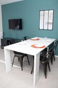 a white dining room table with chairs and a mirror at Studio tout équipé centre-Ville proche de la gare in Cluses