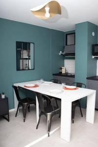 a dining room with a white table and black chairs at Studio tout équipé centre-Ville proche de la gare in Cluses