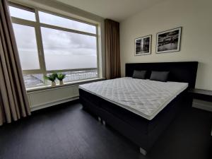 1 dormitorio con cama y ventana grande en K50167Spacious and modern apartment near the city center, free parking en Eindhoven