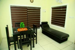 sala de estar con mesa y sofá en DAYA AYURVILLAGE, en Kottakkal