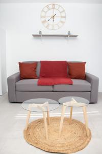Zwei Tische vor einem Sofa mit einer Uhr in der Unterkunft Studio tout équipé centre-Ville proche de la gare in Cluses