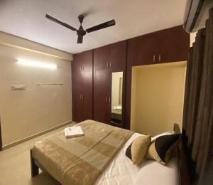 a bedroom with a bed with a ceiling fan at The Pearl 1Bhk / 2Bhk in Chennai