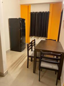 a dining room with a table and a refrigerator at The Pearl 1Bhk / 2Bhk in Chennai