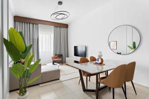 uma sala de estar com uma mesa de jantar e um espelho em Silkhaus Modern Living Studio in Art Residence no Dubai