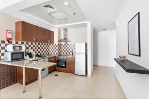 a kitchen with a refrigerator and a counter top at Silkhaus Modern Living Studio in Art Residence in Dubai