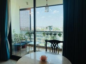 a table and chairs in a room with a large window at 35 Sahakar Suites-A Luxury Aparthotel in Jaipur in Jaipur