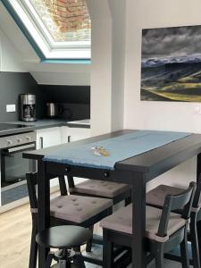 una cocina con una mesa con sillas y una pintura en En plein coeur du Crotoy, un pied à terre en Baie, en Le Crotoy