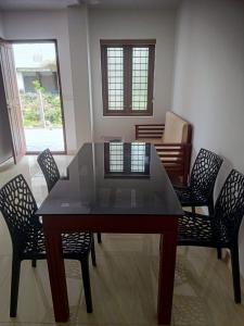 a dining room table with four chairs and a table and a table and chairsktop at Grace Mary Residency in Nedumbassery