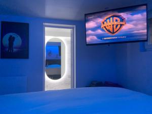 een slaapkamer met een bed en een flatscreen-tv bij *Romance Jacuzzi* Appartement Spa pour les amoureux ou les solos in Deuil-la-Barre