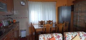 a kitchen with a table and chairs and a refrigerator at Apartamento Carmen en Muxía in Muxia +3 photos