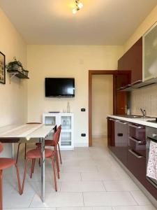eine Küche mit einem Tisch und Stühlen sowie einen TV an der Wand in der Unterkunft Casa Vacanze Fabiola in Castellammare di Stabia