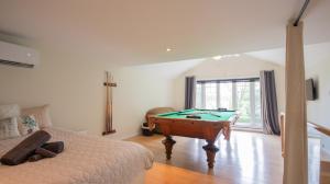a bedroom with a pool table and a bed at Chalet BIA - Cap au Sud in Trois-Lacs