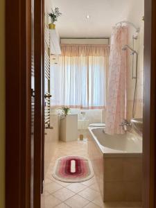 uma casa de banho com uma banheira, um chuveiro e um lavatório. em Casa Vacanze Fabiola em Castellammare di Stabia