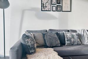 a gray couch with pillows on it in a living room at Luxurious 2 Bed Apartment with Captivating View in Melbourne