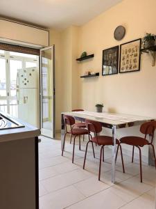 eine Küche mit einem Tisch und Stühlen sowie einem Kühlschrank in der Unterkunft Casa Vacanze Fabiola in Castellammare di Stabia