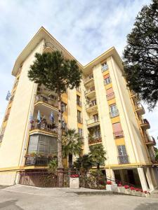 um edifício amarelo com uma palmeira em frente em Casa Vacanze Fabiola em Castellammare di Stabia