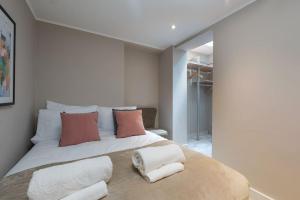 a bedroom with a large bed with two pillows at West Kensington by Capital in London