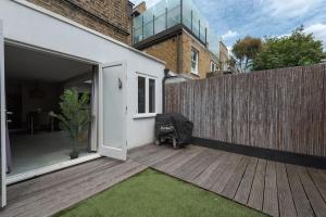 an open door to a backyard with a wooden fence at West Kensington by Capital in London