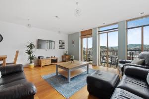 a living room with a couch and a table at By the Bridge by Toppo in Inverness