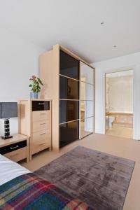 a bedroom with a bed and a dresser and a mirror at By the Bridge by Toppo in Inverness