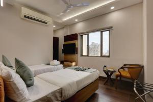a hotel room with two beds and a window at Hotel Ozone Inn Colaba in Mumbai