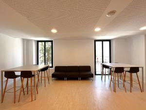 a living room with two tables and a couch at Cal Maco Alberg i centre de visitants in Igualada