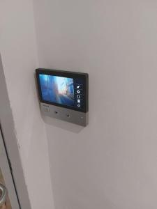 Elle comprend une télévision à écran plat sur un mur blanc. dans l'établissement Appartement, Langres, à Langres