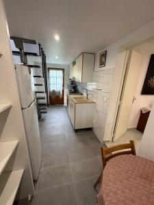 een kleine keuken met een koelkast en een tafel bij T2 avec jardin au calme,parking privé in Buchelay