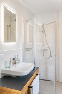 a white bathroom with a sink and a shower at Apartments Am Dorfplatzl in Hohentauern